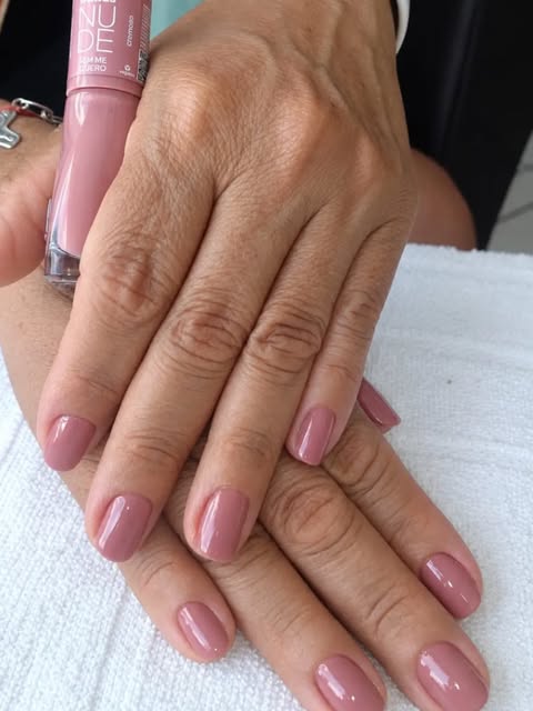 Unhas esmaltadas em tom nude rosado